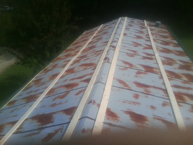 Rusted metal roof panels with new wood purlins before replacement — Storm Damage Roof Repair in Waukon by Roofing Brothers