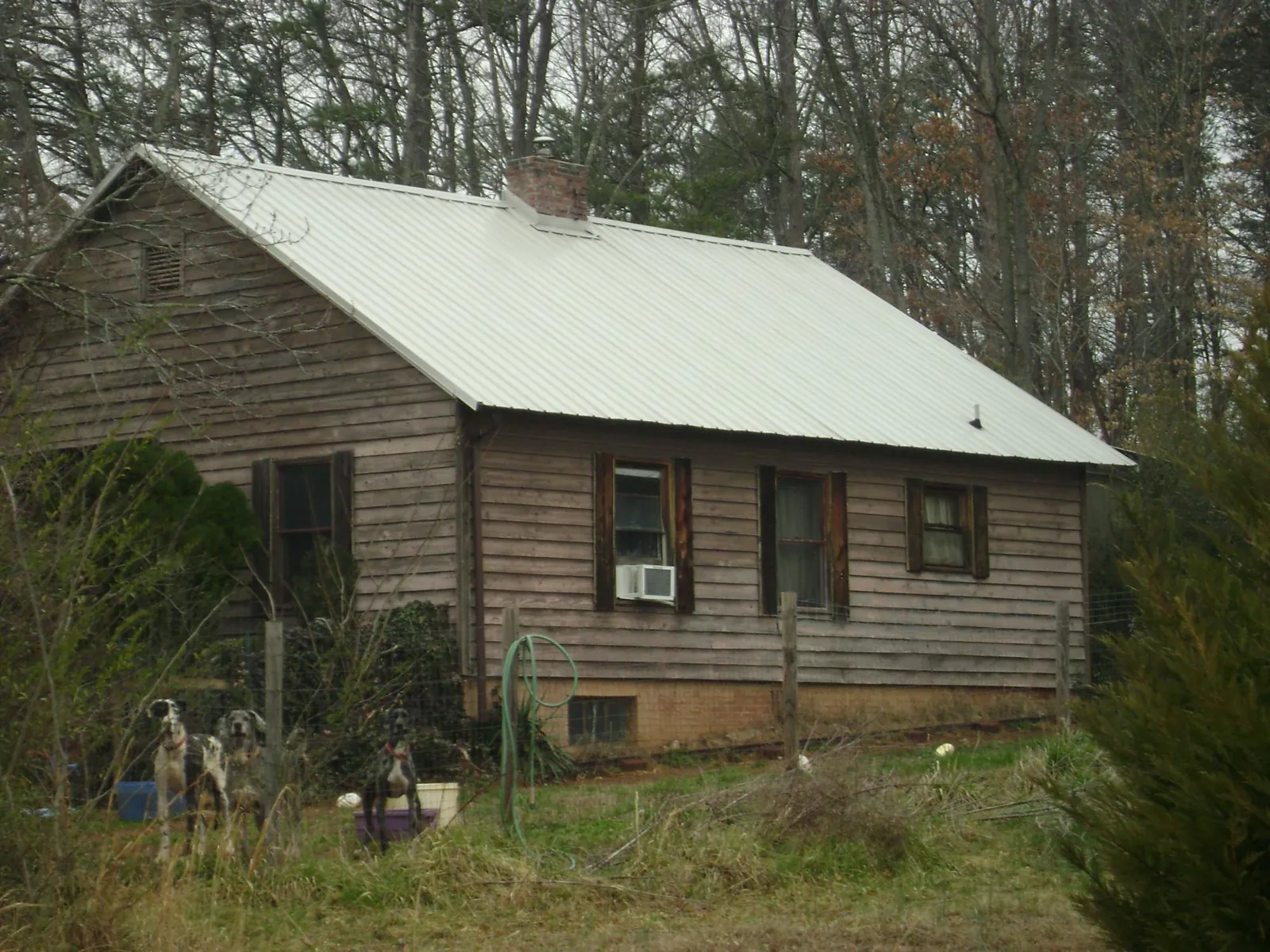White metal roof on an old wood sided farmhouse, from a Metal Roof Installation job in Waukon